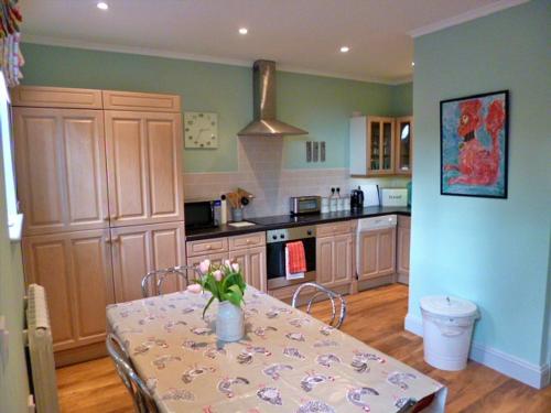 a kitchen with a table with a vase of flowers on it at Finest Retreats - No 2 Meynell Mews in Breedon on the Hill