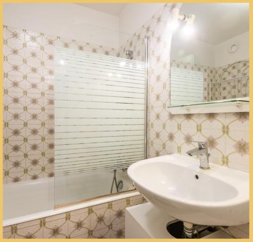 W łazience znajduje się umywalka, wanna i lustro. w obiekcie Studio / Chaleureux / Marignier w mieście Marignier