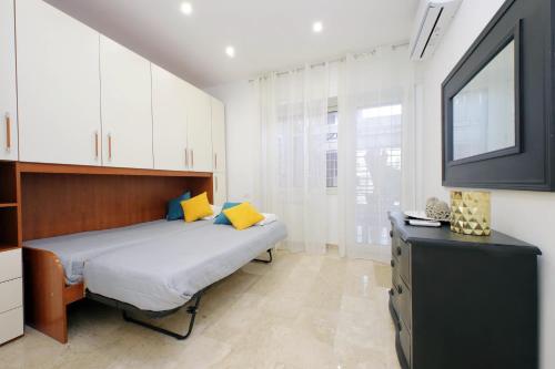 1 dormitorio con 1 cama con almohadas amarillas y TV en Lovely apartment with terrace near the Vatican en Roma