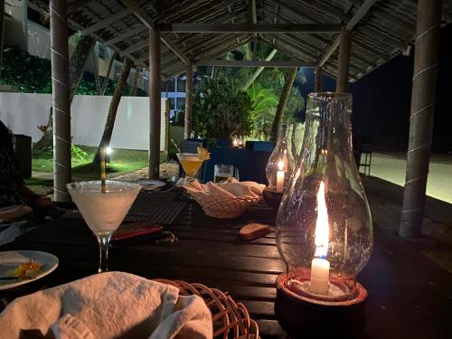 a table with a candle and glasses on it at Suite Lanka in Hikkaduwa