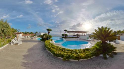 a resort with a swimming pool and palm trees at Residence Il Cicero in Porto San Giorgio