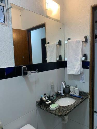 a bathroom with a sink and a mirror at Casa próximo ao aeroporto in Rio Largo