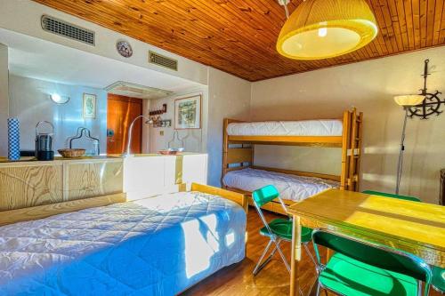 a bedroom with two bunk beds and a table and a dining room at Appartamento La Chapelle Chaberton - Affitti Brevi Italia in Sauze dʼOulx