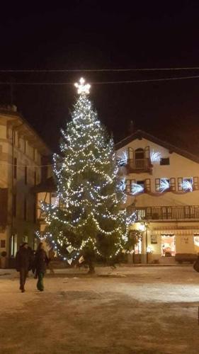 a christmas tree with lights in front of a building at Joie de Vivre Gressoney St Jean in Gressoney-Saint-Jean