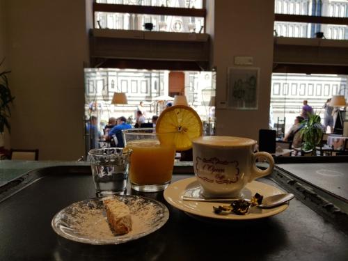 een tafel met een bord eten en een kop sinaasappelsap bij LunArt in Florence