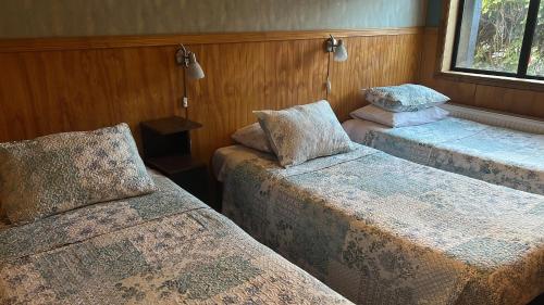 a room with two beds and a window at HOSTAL VICTORIA in Punta Arenas