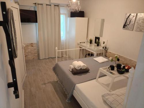 a small bedroom with a bed and a table at Cocomelo Apts in Heraklio Town