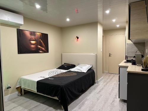 une chambre avec un lit et un tableau au mur dans l'établissement Village naturiste - Port-Vénus - Studio Le Vénus -, au Cap d'Agde