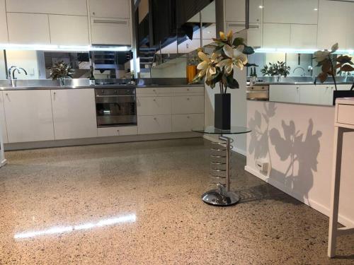 a kitchen with a vase of flowers on a table at WAREHOUSE! RARE!! NEW ARCHITECTURALLY DESIGNED MASTERPIECE!! BEST LOCAT! MASSIVE! PRIVATE ROOFTOP GARDEN w PANORAMIC CITY VIEWS!!! (B1-51-ImpAbb) in Sydney