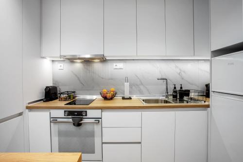 a kitchen with white cabinets and a sink at Airbnb Kastoria - Bella Vista B in Kastoria