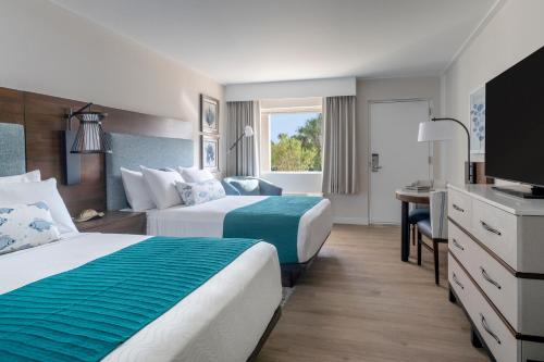 Habitación de hotel con 2 camas y escritorio en Sanibel Island Beach Resort en Sanibel