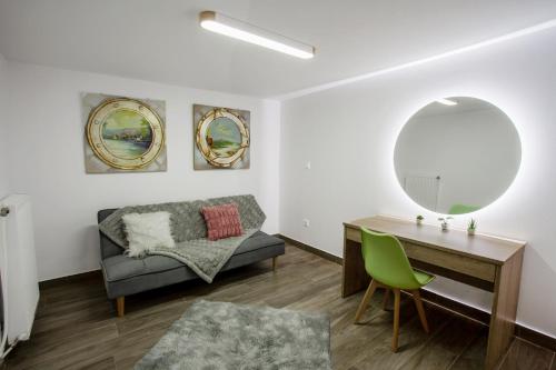 salon z kanapą, biurkiem i lustrem w obiekcie Airbnb Kastoria - Bella Vista B w mieście Kastoria