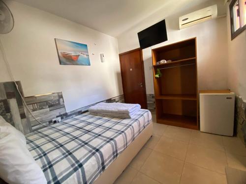 a small bedroom with a bed and a tv at Marina's Rooms Xrisopolitissa Larnaca in Larnaca