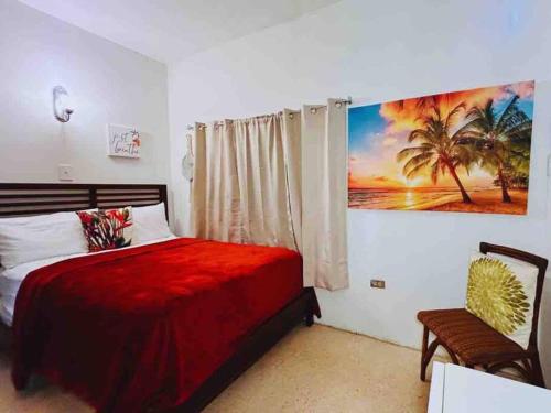 a bedroom with a red bed and a painting on the wall at Cozy Vacation Home -San Juan -Centric location in San Juan
