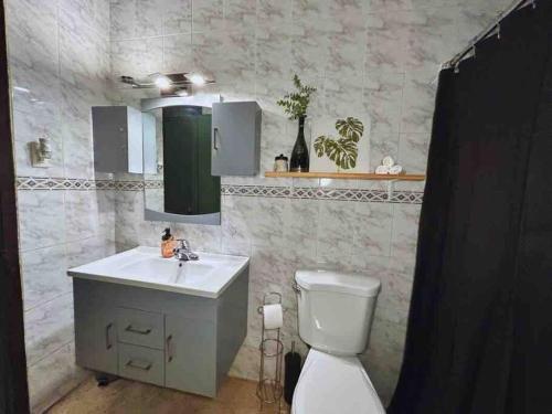 a bathroom with a white toilet and a sink at Cozy Vacation Home -San Juan -Centric location in San Juan