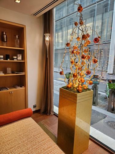 a vase with a sculpture in front of a window at Hôtel Le Colisée in Paris