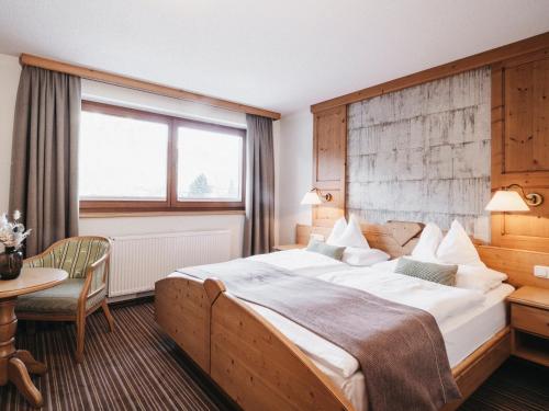 a hotel room with a large bed and a table at Hotel Wagnerhof in Pertisau