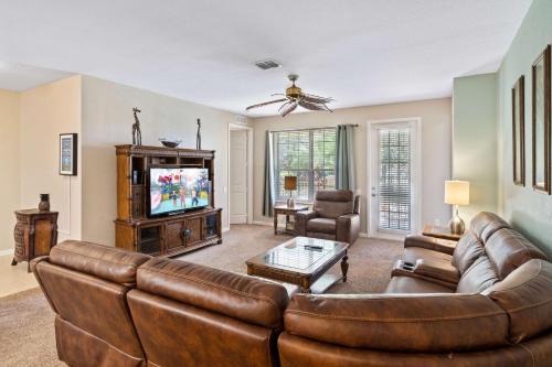 a living room with a couch and a tv at Orlando Resort Rentals at Universal Boulevard in Orlando