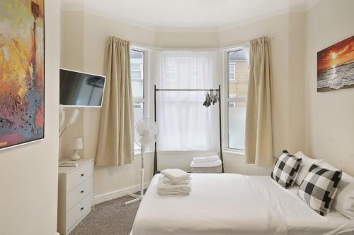 a small bedroom with a bed and a window at LiveStay - One Bedroom Studio Near The Beach in Southend-on-Sea