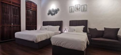 a bedroom with two beds and a couch and a chair at TREASURE HUNTER At Heritage Georgetown in George Town