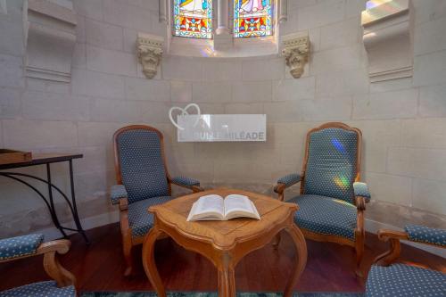 a room with a table with a book on it at Hôtel Miléade Le Domaine de la Blairie - Saumur in Saint-Martin-de-la-Place