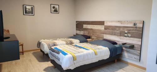 sypialnia z 2 łóżkami i drewnianym zagłówkiem w obiekcie La Villa de l Embusade w mieście Pont-à-Mousson