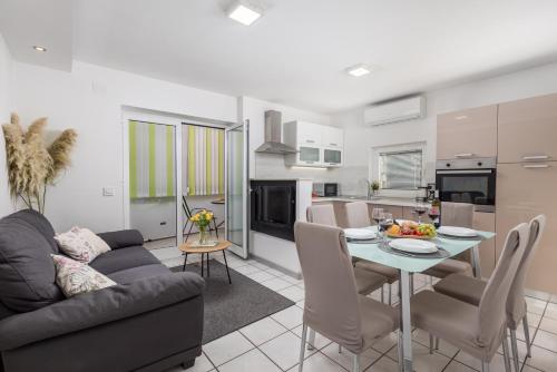 a living room and kitchen with a table and a couch at Apartment City flower in Rijeka