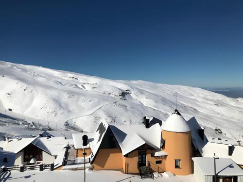 un edificio cubierto de nieve en una montaña nevada en Apartamento Zona Alta Sierra Nevada, en Sierra Nevada