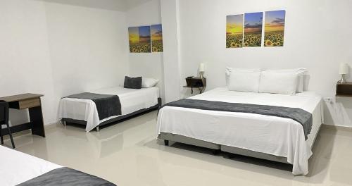 1 dormitorio con 2 camas, escritorio y mesa en Hotel El Marqués De Manga, en Cartagena de Indias