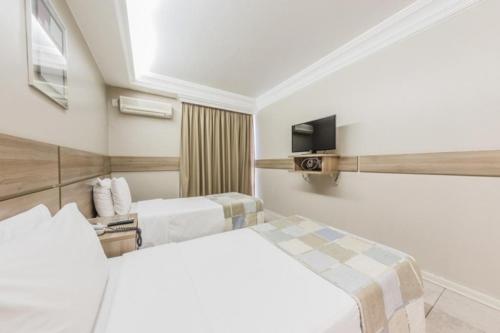 a hotel room with two beds and a tv at Plaza Bittar Hotel in Brasília