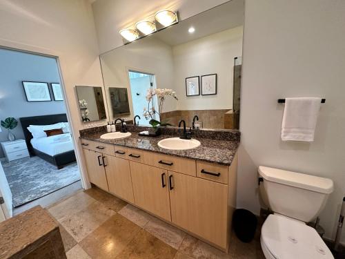 a bathroom with two sinks and a toilet and a mirror at Old Town Pied-a-Terre with Private Terrace and Parking! in Chicago