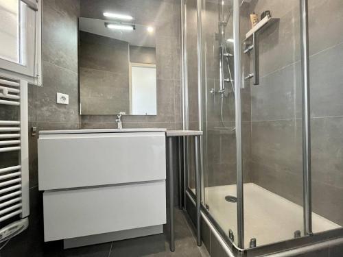 La salle de bains est pourvue d'une douche et d'un lavabo blanc. dans l'établissement Bel appartement P2 climatisé vue sur mer pour 2/4 pers avec terrasse et parking, au Grau-du-Roi