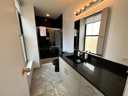 uma casa de banho com um lavatório preto e um espelho em River North Hideaway with Amazing Views and Parking em Chicago