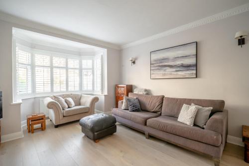 Enjoy a Luxury & Peaceful Home in Loughton, Essex في لوثيون: غرفة معيشة مع أريكة وكرسي