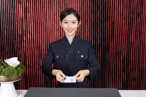 a woman standing in front of a table holding a card at HUALUXE Yangjiang City Center in Yangjiang