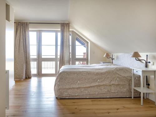 um quarto branco com uma cama e uma janela em Ferienwohnung mit Kamin im Gut Ulrichshusen em Tressow