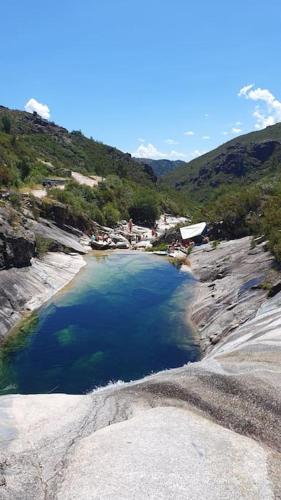 a large pool of water on the side of a mountain at Refúgio do Agricultor - Gerês in Montalegre
