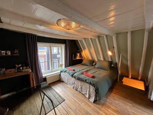sypialnia z łóżkiem i oknem w obiekcie Attic Monkeys Lodge w Amsterdamie