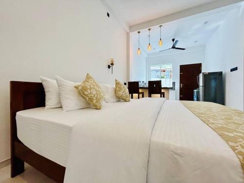 een slaapkamer met een groot wit bed met kussens bij The Palazzo - Weligama in Weligama