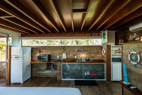 Il comprend une cuisine dotée de plafonds en bois et d'une grande fenêtre. dans l'établissement Pousada Village Feliz Boipeba, à Île de Boipeba