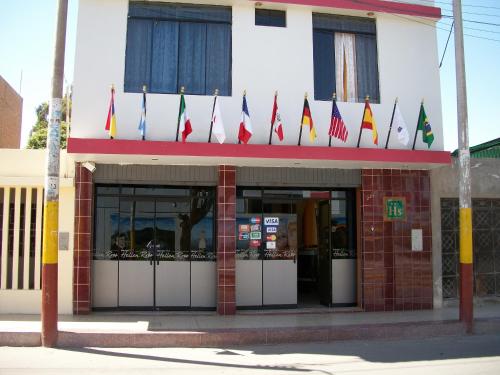 a building with different flags in front of it at Hostal Hellen Ross in Nazca