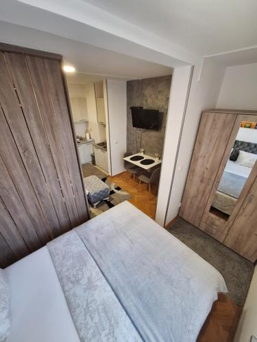 um quarto com uma cama e um quarto com uma televisão em Dado apartman em Kraljevo