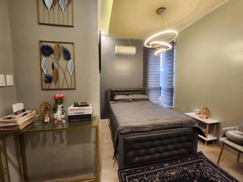 Schlafzimmer mit einem Bett, einem Tisch und einem Schreibtisch in der Unterkunft 4 bedrooms Newly Build Vacation House in Bacolod City