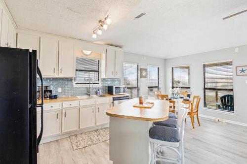a kitchen with white cabinets and a black refrigerator at 045 Dooney Dunes in Dauphin Island