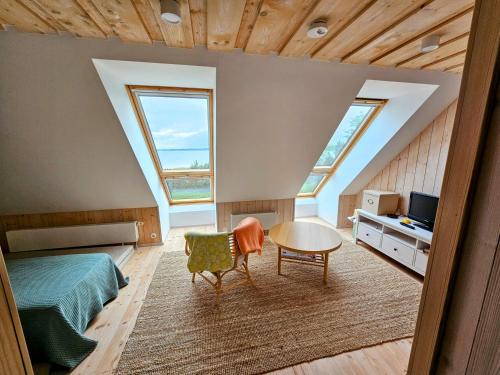 a bedroom with a bed and a table and two windows at Puulaiu kõrts majutus in Nasva