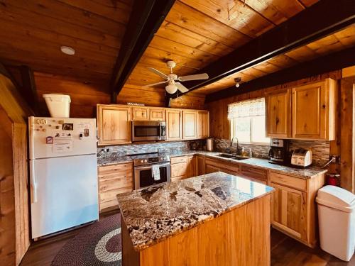 eine Küche mit Holzschränken und einem weißen Kühlschrank in der Unterkunft Hole-In-1 Yellowstone Getaway - Sleeps 6 in Rea