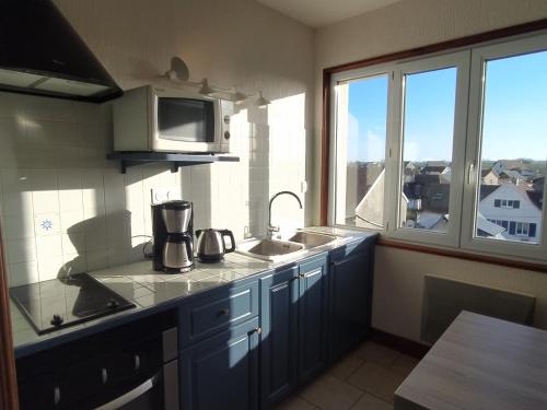 a kitchen with a sink and a microwave at Gîtes en Normandie en FRONT DE MER à Asnelles , 3km d'Arromanches, 10km de Bayeux in Asnelles