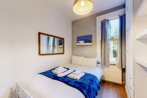 1 dormitorio con 1 cama con 2 toallas en Stunning 2BDR with beautiful garden en Londres