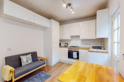 a living room with a couch and a kitchen at Stunning 2BDR with beautiful garden in London