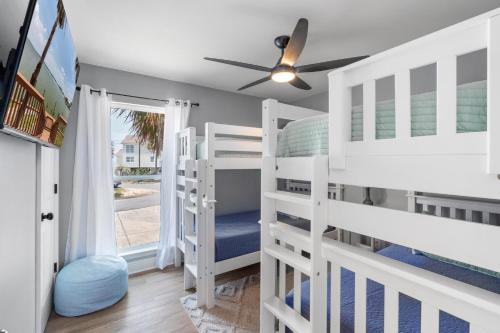 a bedroom with two bunk beds and a ceiling fan at 061 Bay Breezes on Port Royal in Dauphin Island